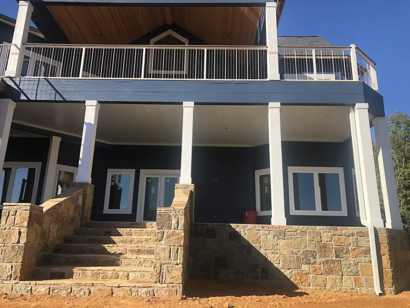 Two-story home with stone steps, covered porch, and upper deck