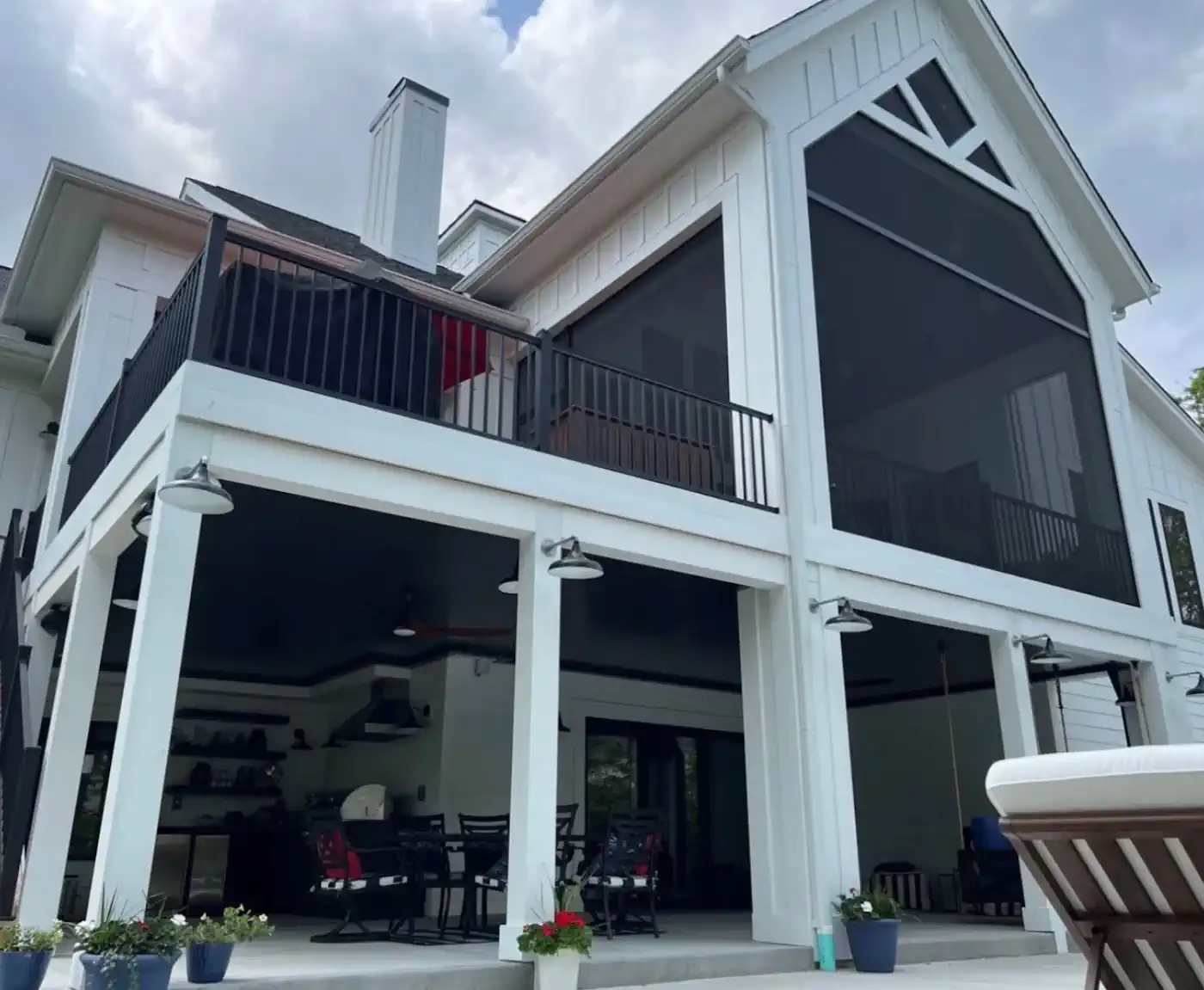 Two-story white home with screened porch and open patio below