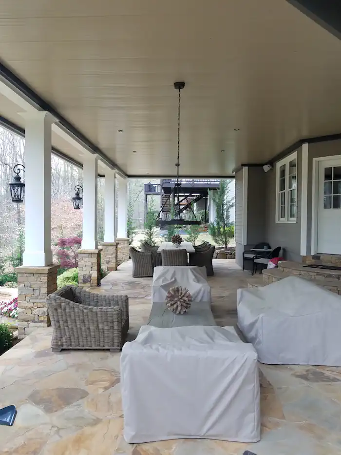 Covered porch with stone columns and covered outdoor furniture
