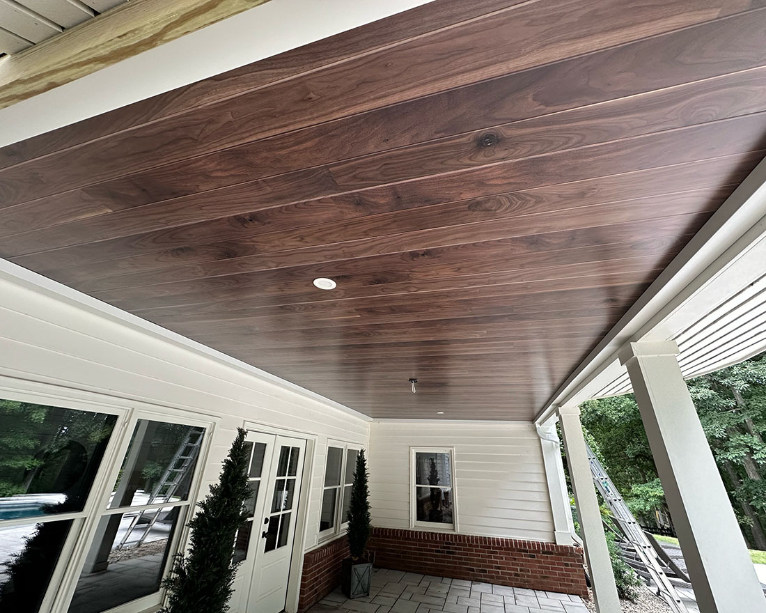 Elegant dark wood plank ceiling on covered outdoor porch