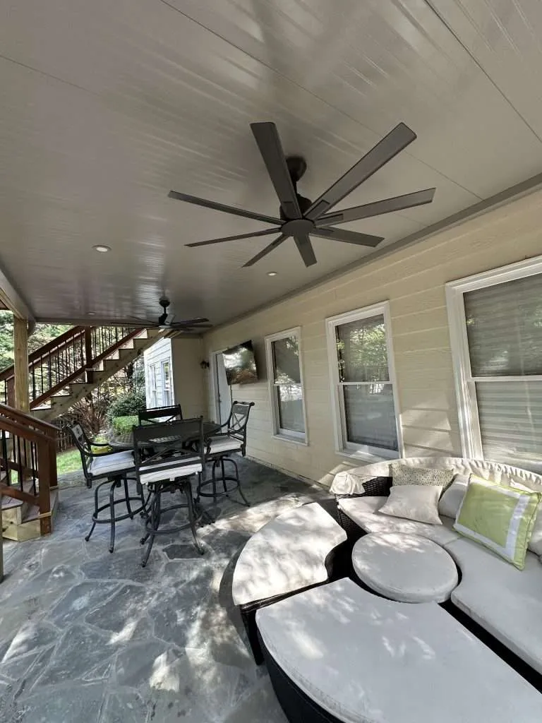 Covered patio with ceiling fan, outdoor seating, and dining area